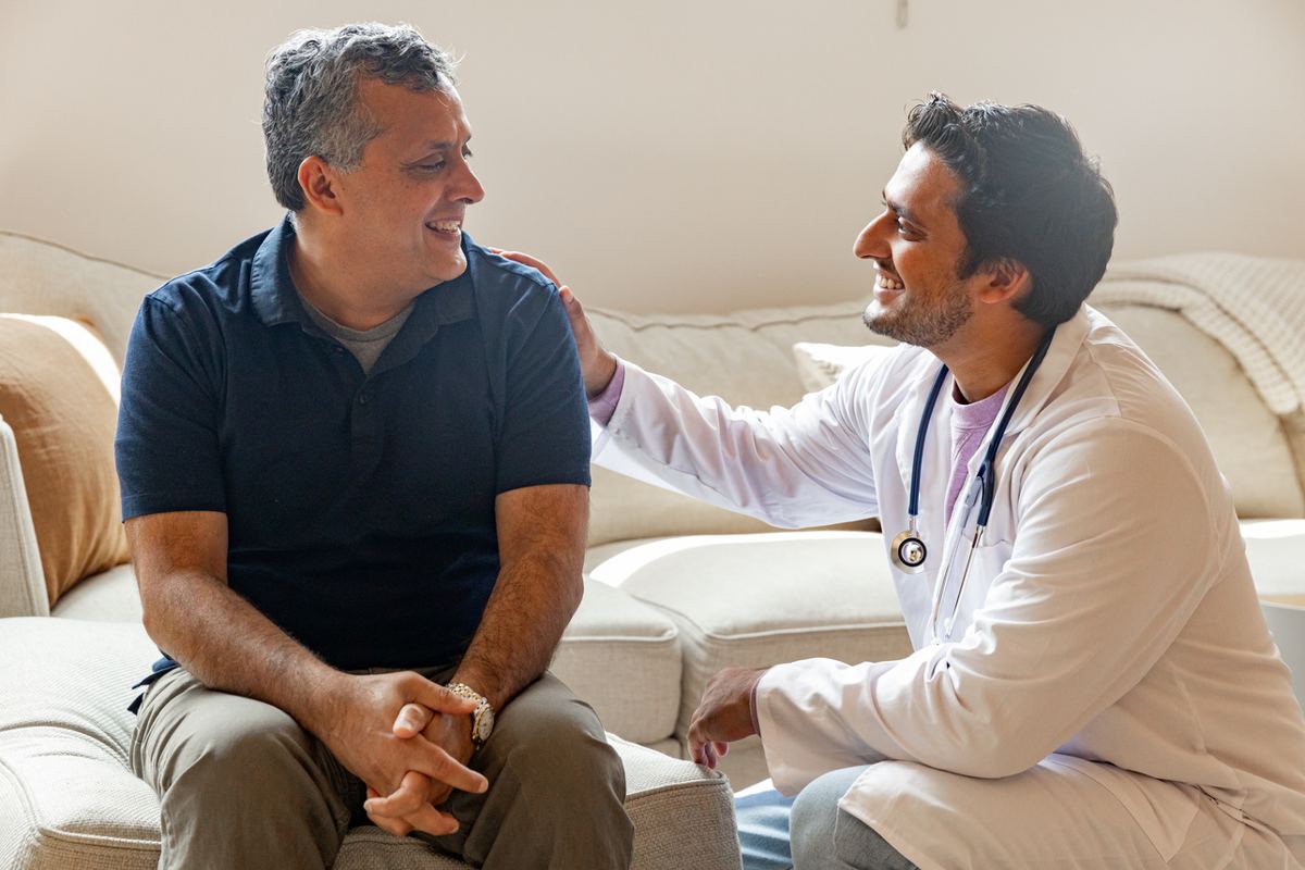 A physician speaking with a patient at home